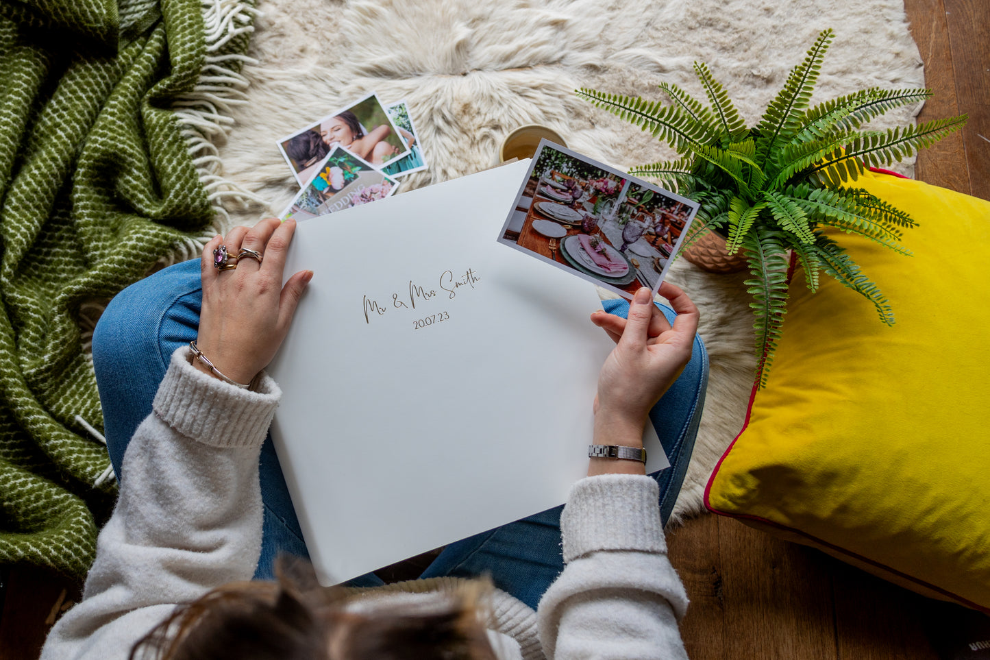 A lady adding photographs to a wedding photo album