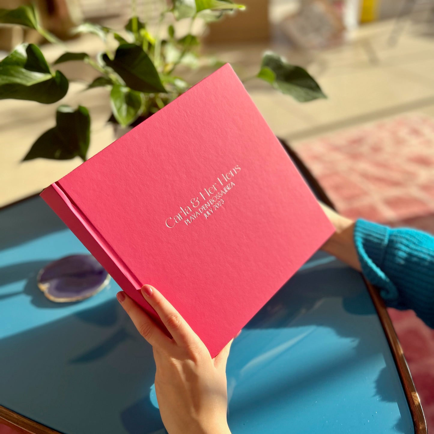 a women looking through a hot pink photo album of hen do photographs