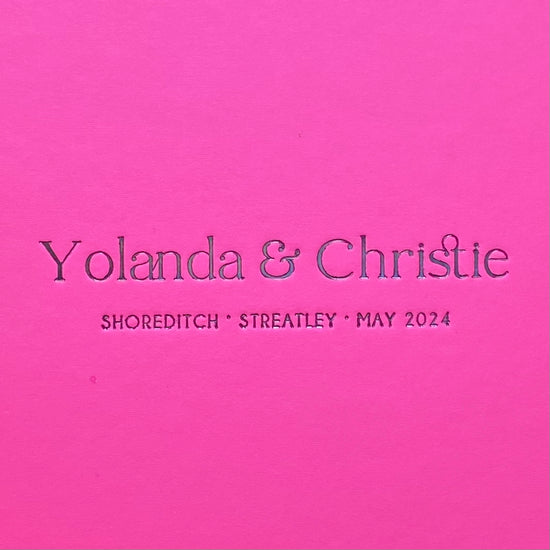 a close up of a pink cover showing wedding details printed in black