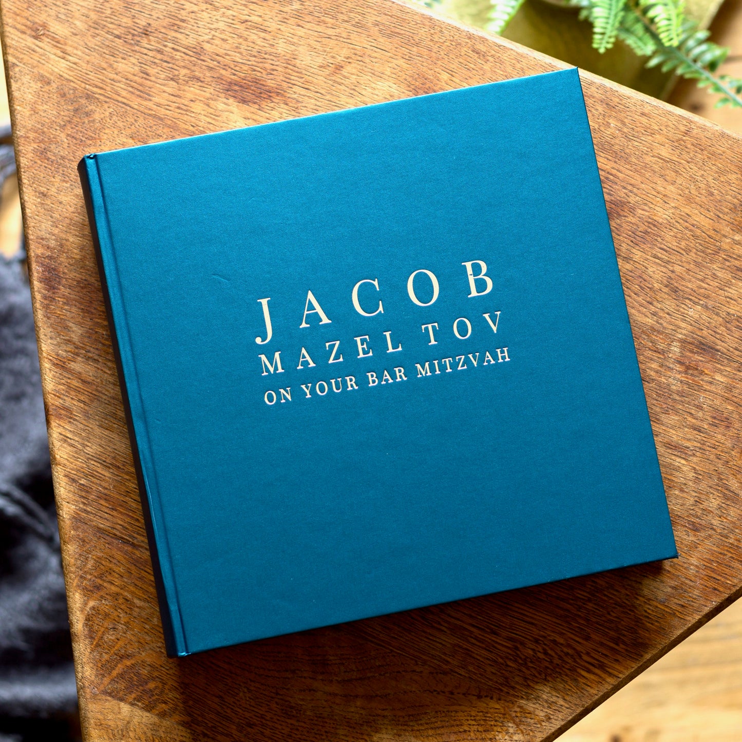 bold and bright bar mitzvah album resting on a wooden table