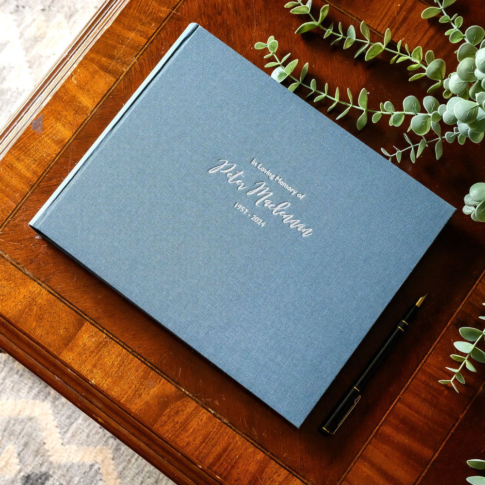 Navy blue condolence book resting on a coffee table
