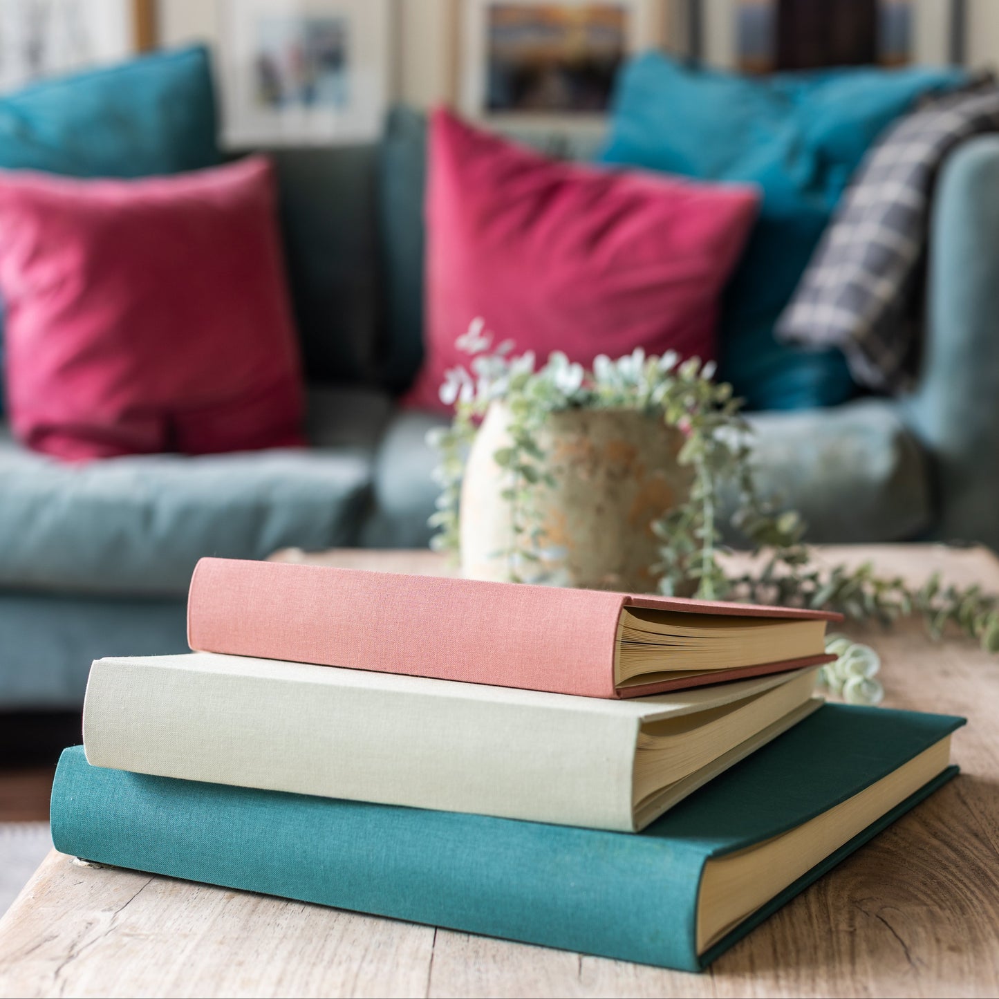 Plain cover linen photo albums in different colours piled up on a table