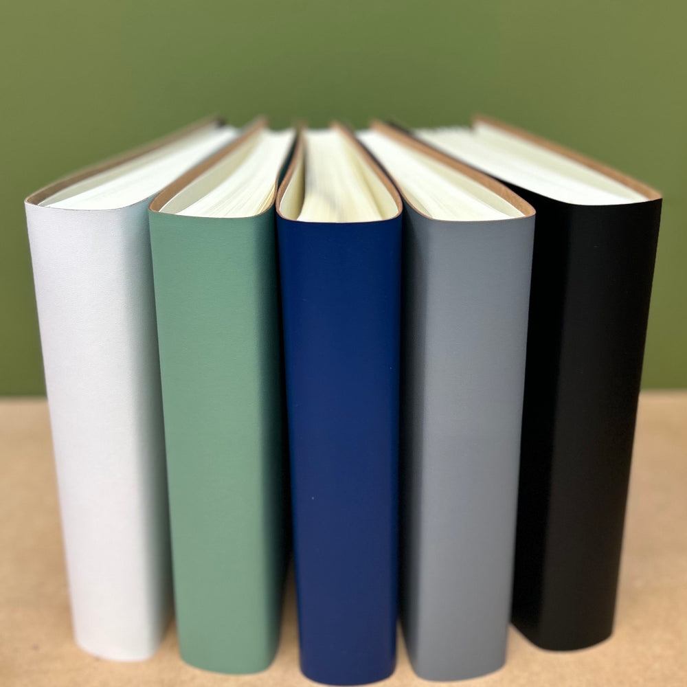 
                      
                        5 different colour condolence books standing up right on a table 
                      
                    