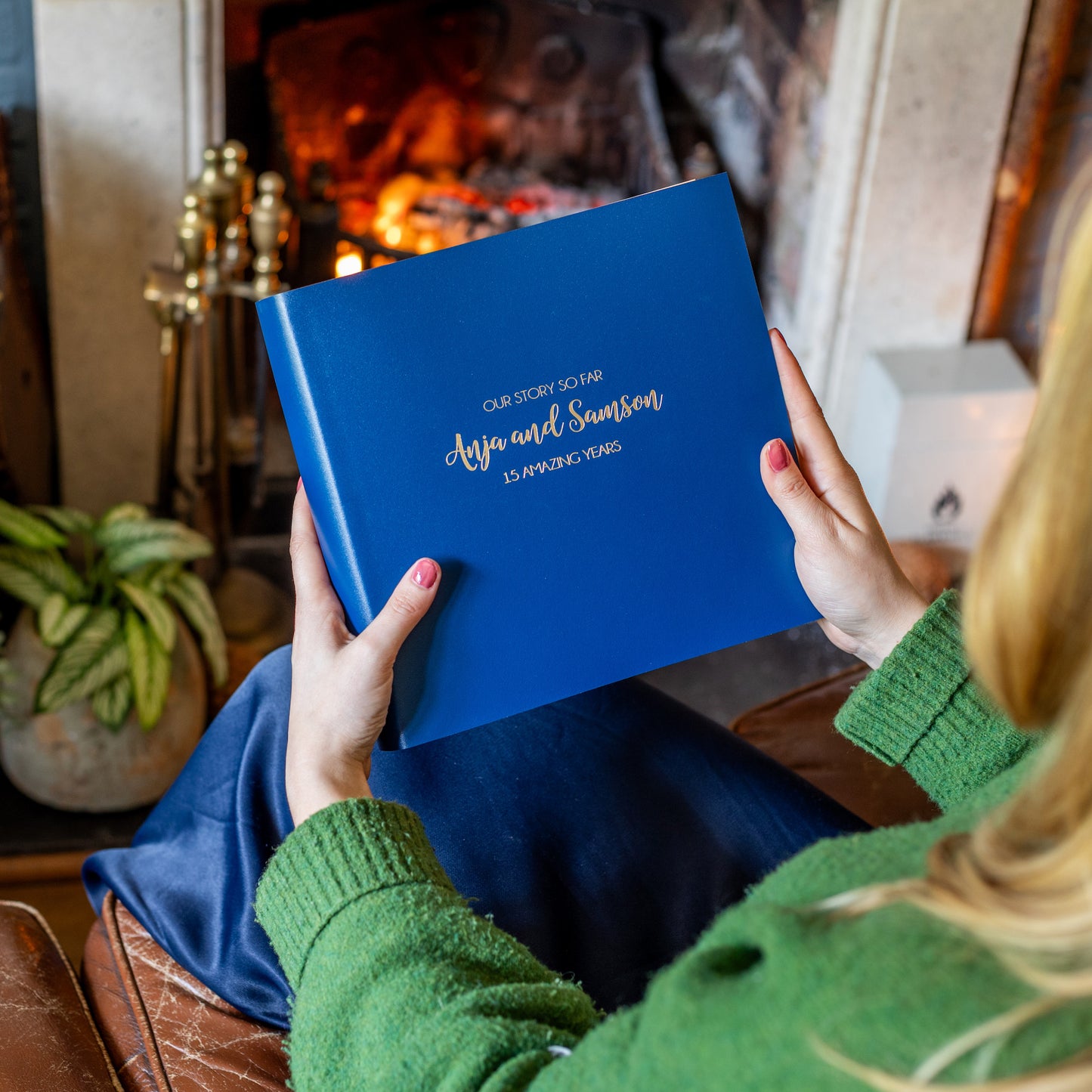 A woman is holding a medium sized photo album. There is a personalisation on the front using gold hot foil. 