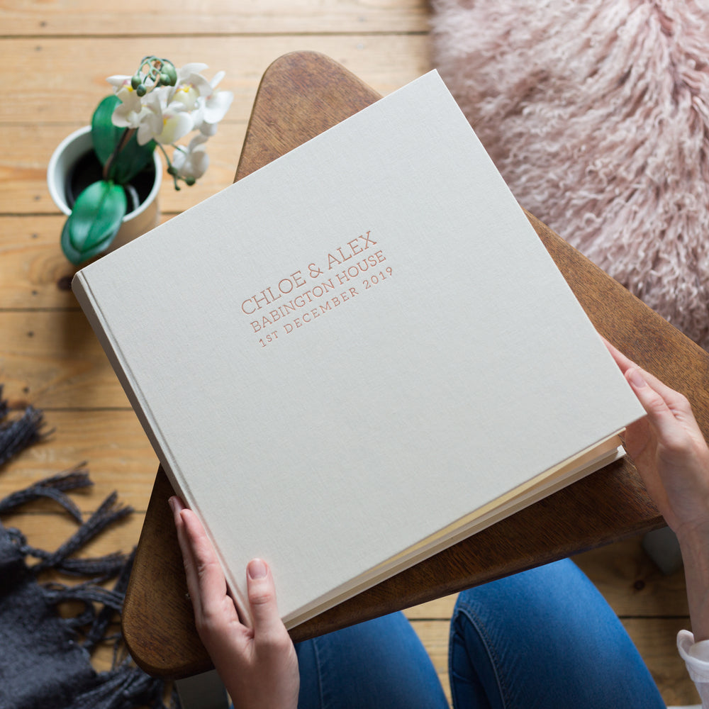 
                      
                        A beautiful ivory wedding album resting on a table
                      
                    