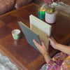 a woman is looking through her wedding guest book, she is wearing a flowery dress 