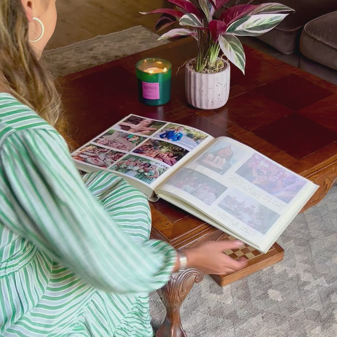 A lady looking though a wedding album resting on a coffee table