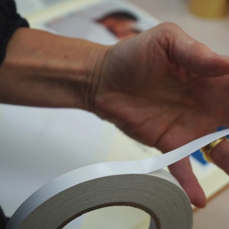 A video showing how to stick photos into an album using double-sided tape.
