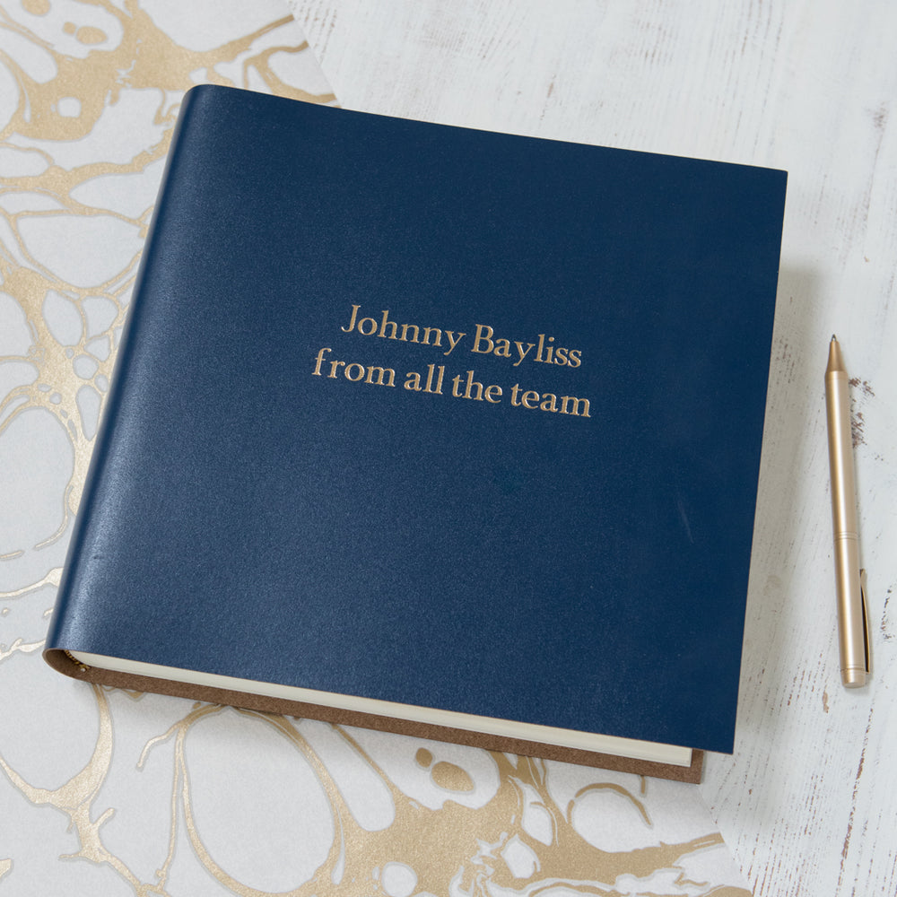 
                      
                        Another large retirement book is on a white background. You can see that it has been personalised with gold writing.
                      
                    