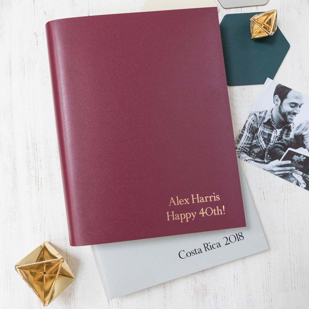 Burgundy and grey photograph albums lying on a table