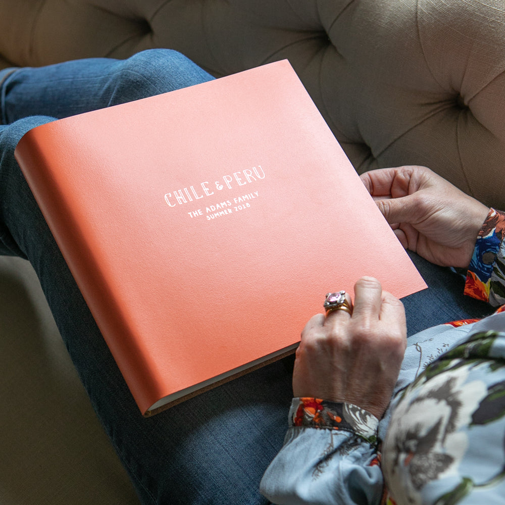 
                      
                        A lady sitting on a sofa about to start flicking through a family travelling album
                      
                    