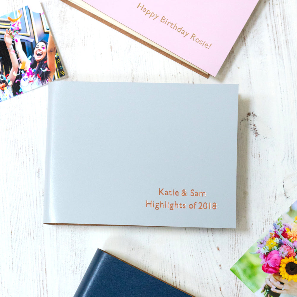 
                      
                        three little photo albums are on a white table and you can see clearly the personalisation on the front
                      
                    