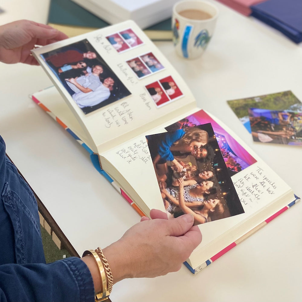 
                      
                        A lady adding photographs to a scrapbook style album
                      
                    