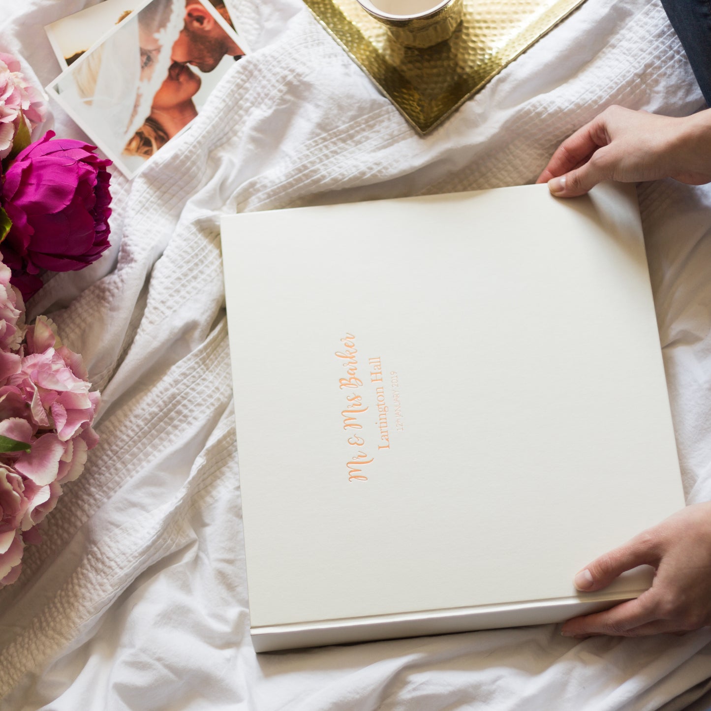 a large photo album has been placed on a bed and someone is about to look through it