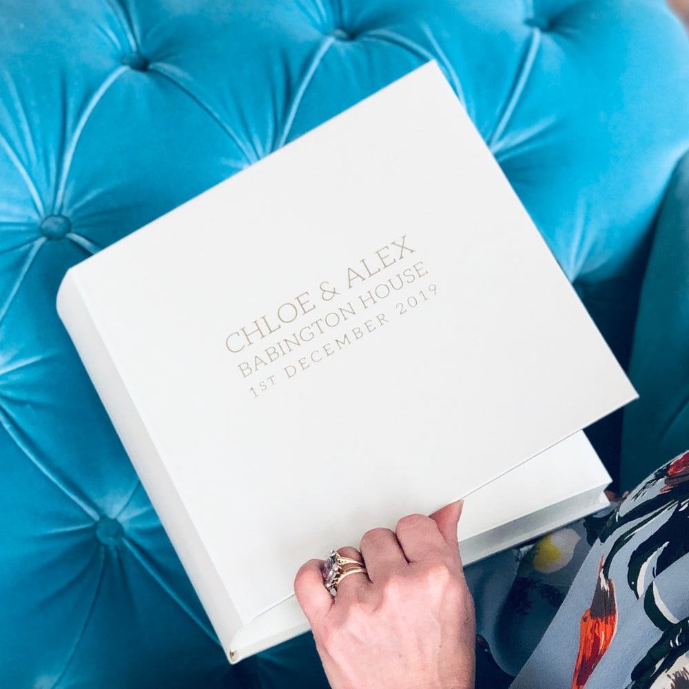 
                      
                        A woman is sat on a blue sofa. She is opening her album ready to reminisce on memories of her special day.
                      
                    